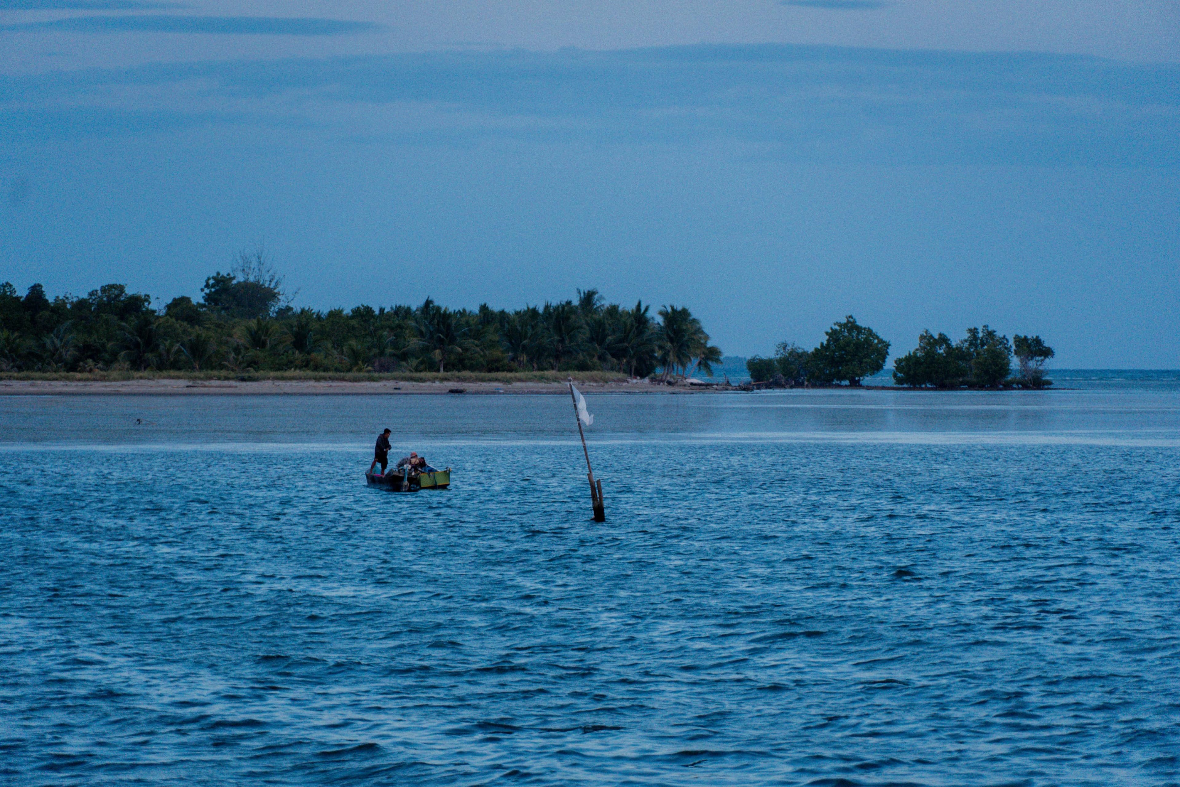 A white flag tied to a wooden pole stands two meters above the ocean surface in Torosiaje, Gorontalo, used by the community to read the wind.